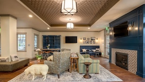 A spacious living room with a fireplace, a large TV, and a cozy seating area.