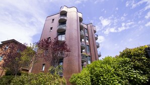 Een meerhoog gebouw met een opvallend architectuur, voorzien van balkons op elke verdieping.