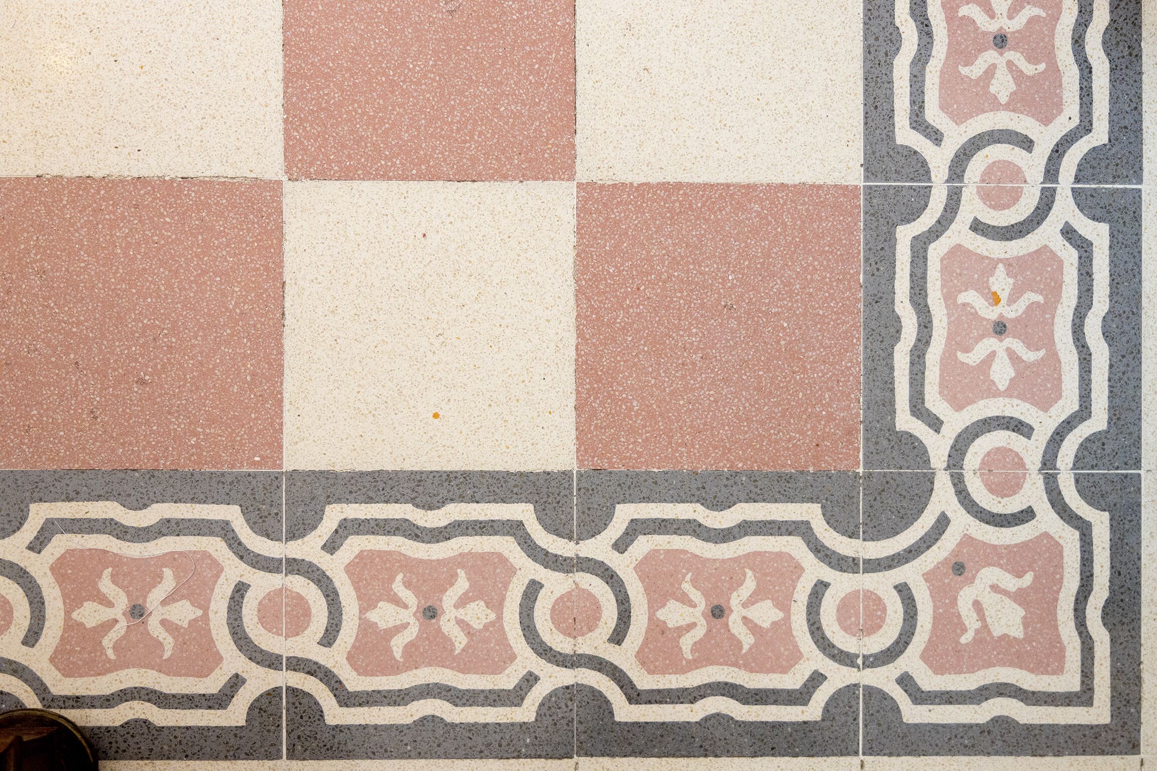 A checkered floor pattern with a decorative border.