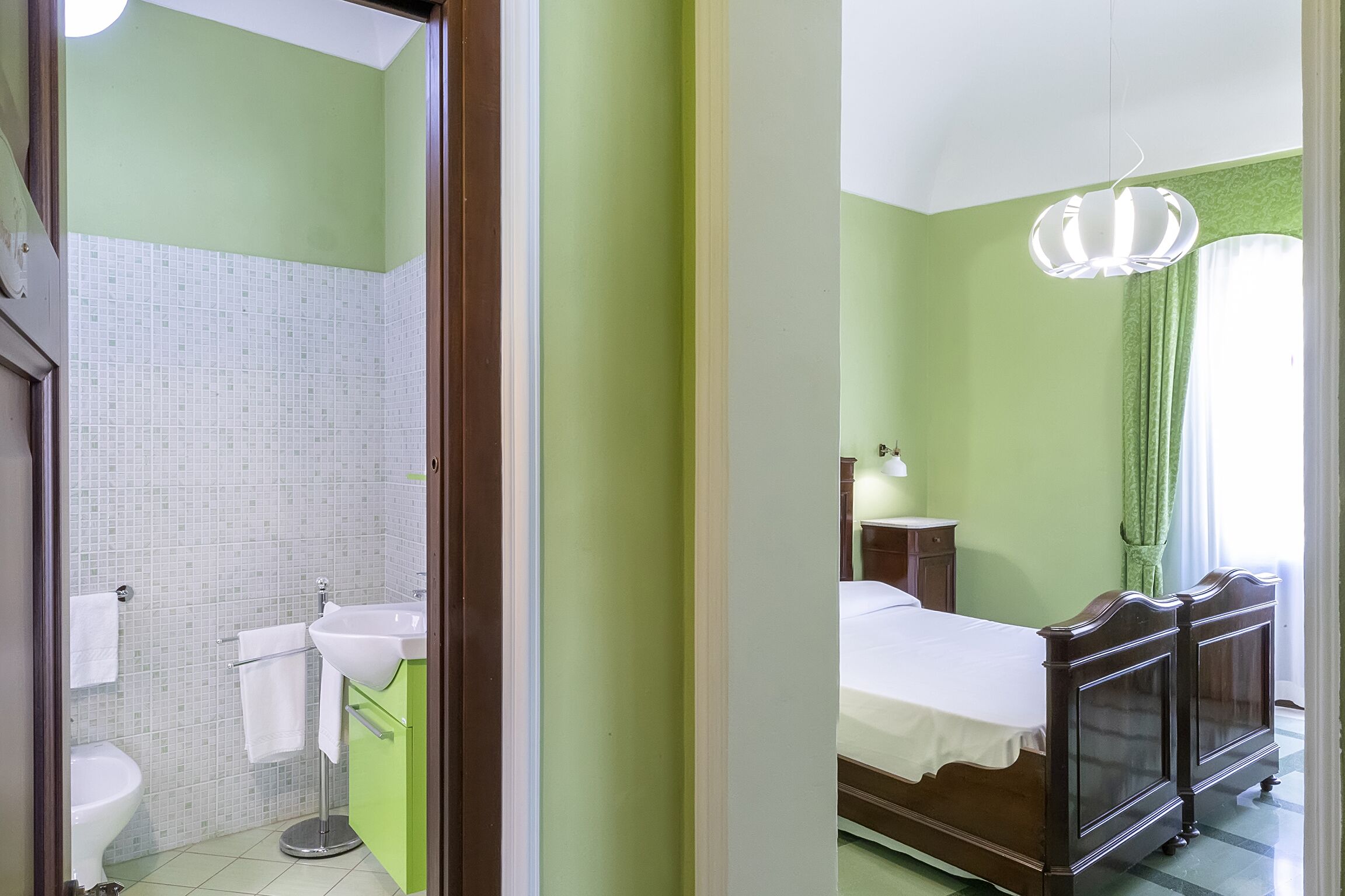 A bathroom with a toilet, sink, and a mirror.