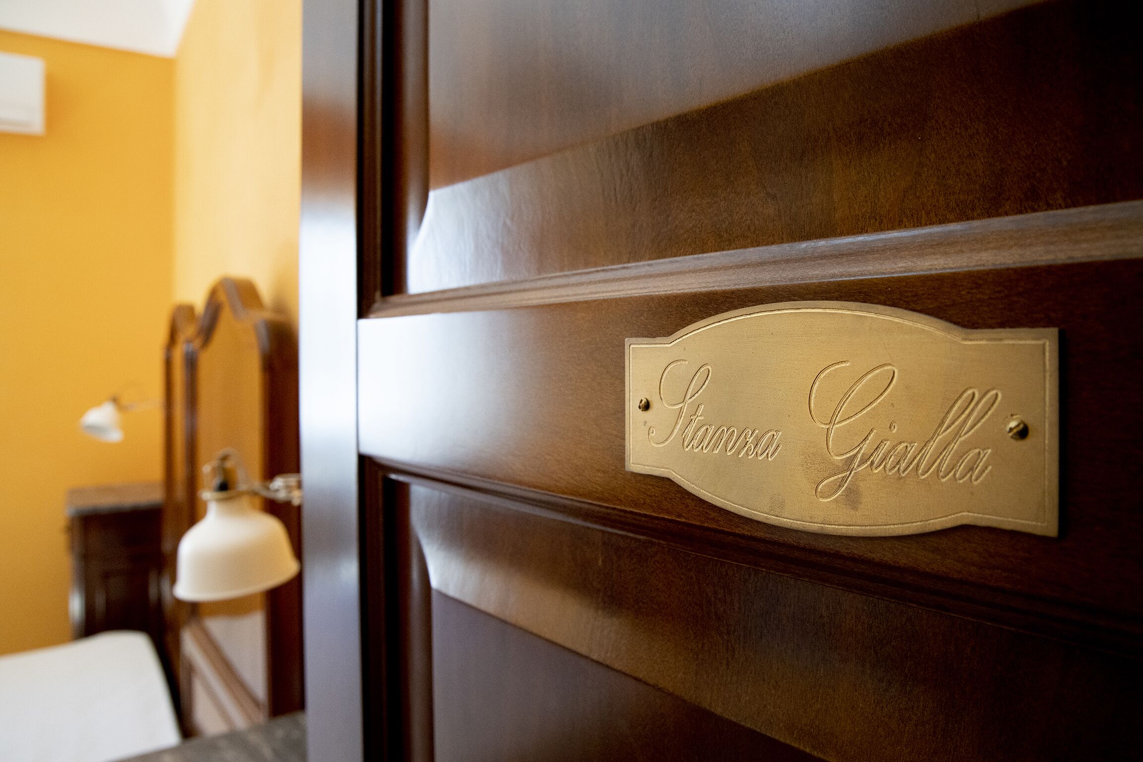Une porte en bois ornée d’une plaque en laiton portant l’inscription « Stanza Giolla ».
