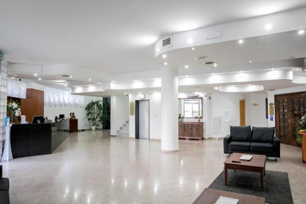 Un'ampia hall con reception, divano e tavolino.