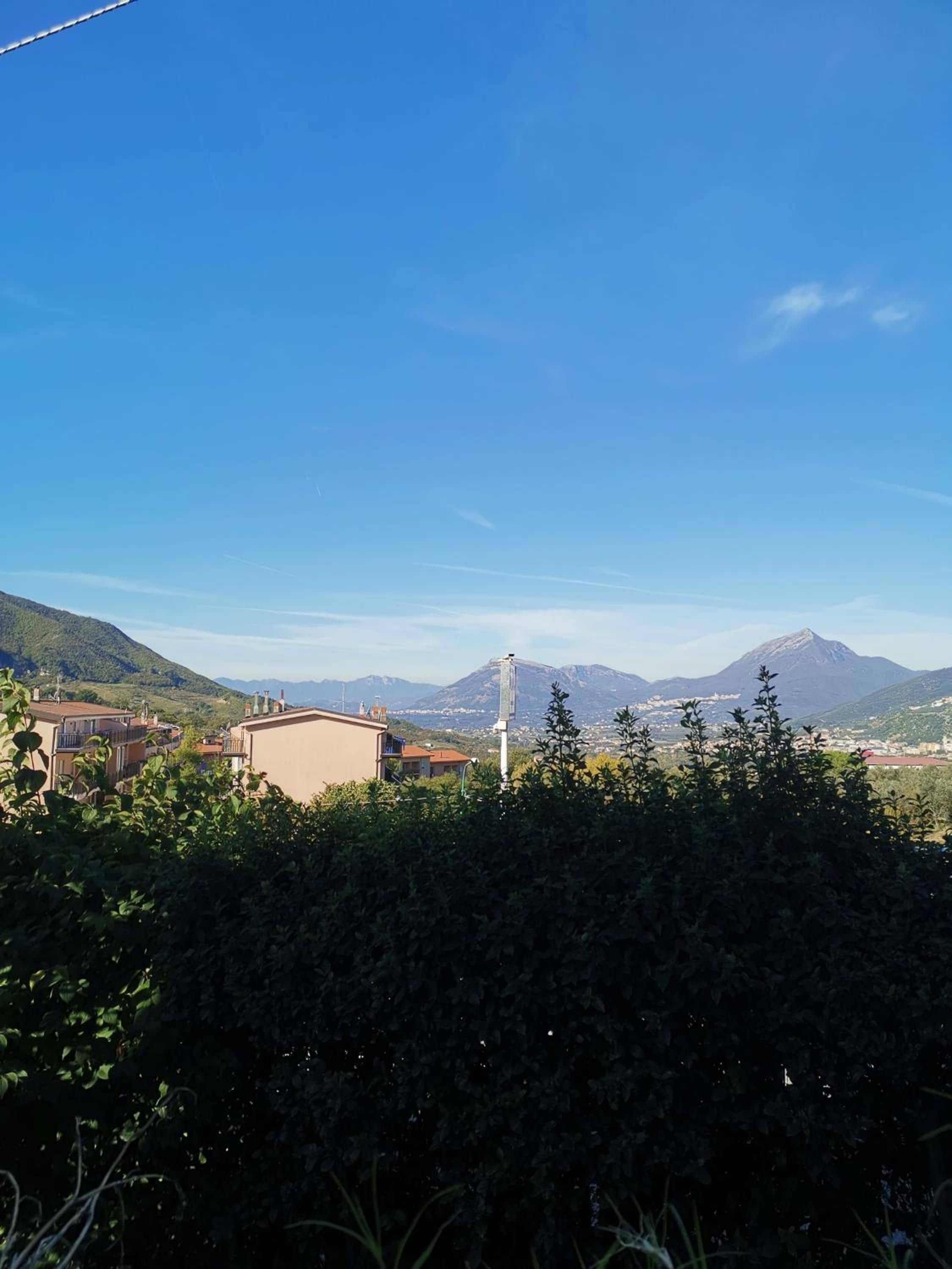 Ein Wohngebiet mit Häusern, einem Berg und einem klaren Himmel.