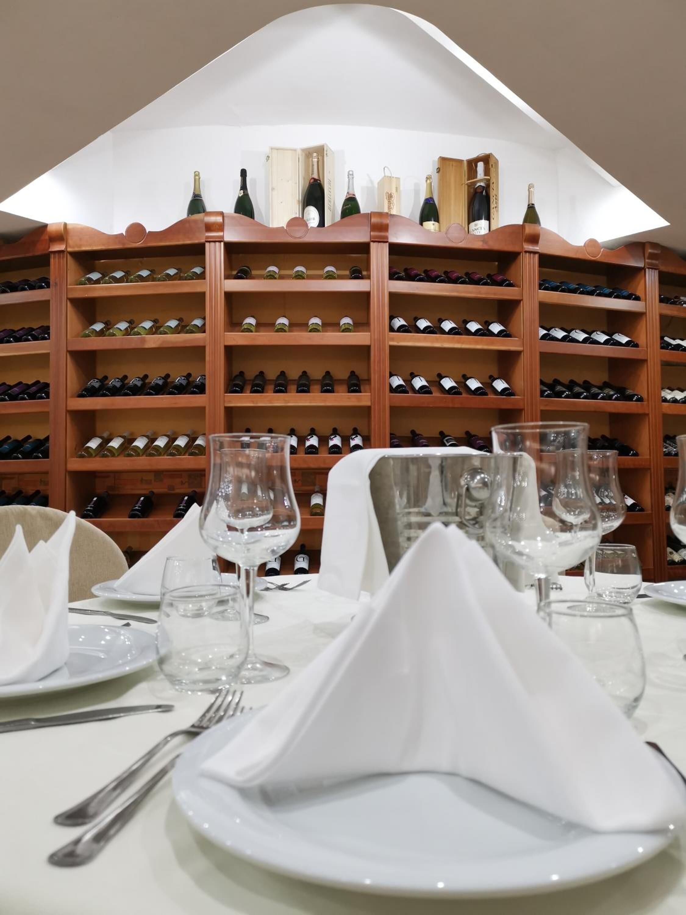 A wine cellar with neatly arranged wine bottles on wooden shelves.