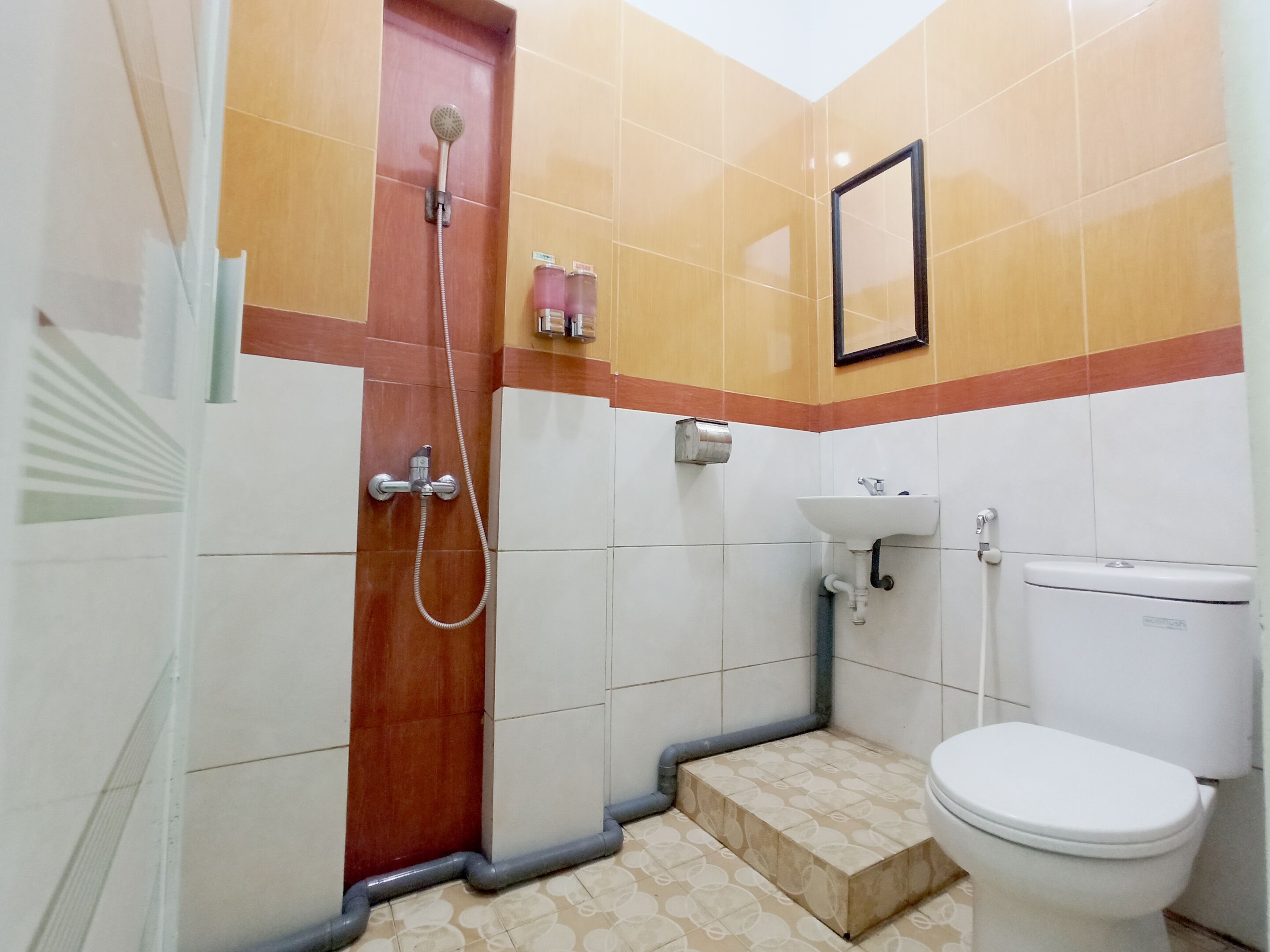 A small bathroom with a shower, toilet, sink, and a mirror on the wall.