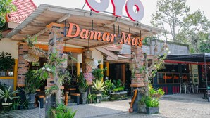 Un edificio con un letrero que dice "Damar Mas Cafe" y "Oyo" en la parte superior.