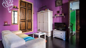 A living room with a sofa, TV, and a cabinet. - Five Trees B&B (Sliema)