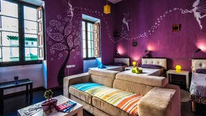 A modern living room with a sofa, a coffee table, and a window with a view of buildings. - Five Trees B&B (Sliema)