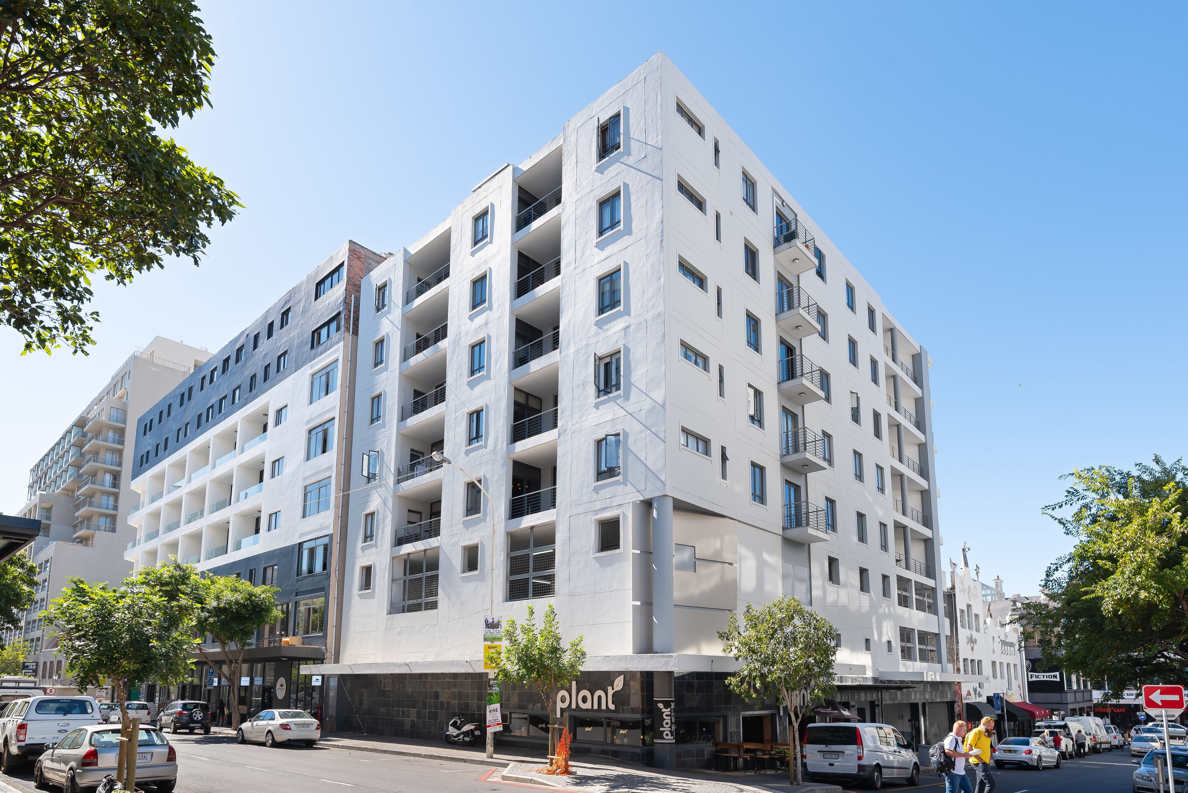 A multi-story building with a modern architectural design, featuring balconies and large windows.
