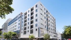 A multi-story building with a modern architectural design, featuring balconies and large windows. - Flatrock 703 (Cape Town)