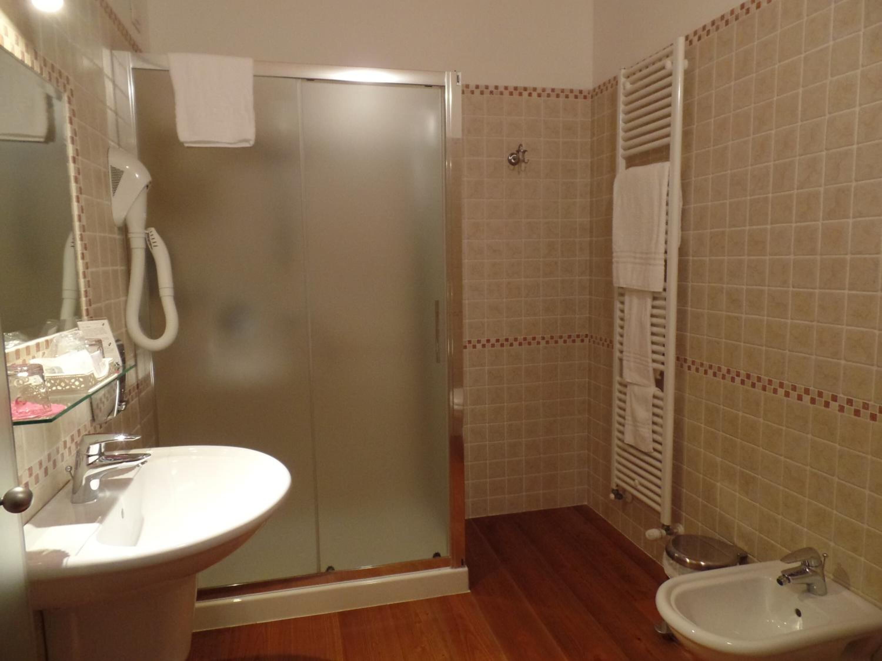 Un baño con ducha acristalada, lavabo e inodoro.