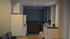 Un espacio habitable compacto con comedor, kitchenette y zona de estar.