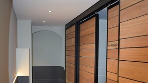 Un pasillo con paneles de madera, suelo de baldosas y una puerta con la leyenda 'Le Bouquin'.