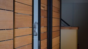 Un pasillo con paneles de madera y una puerta corredera.