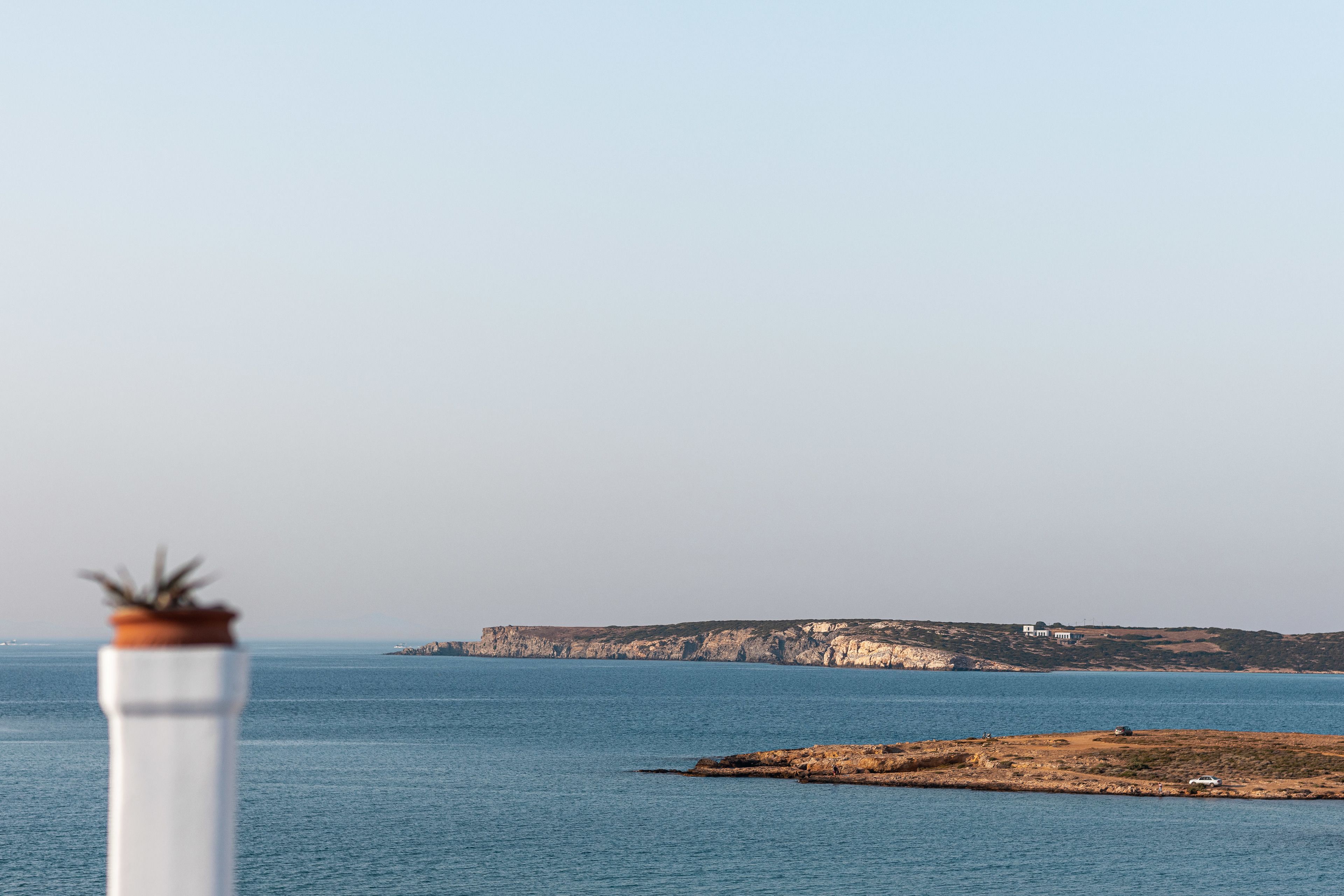 Un paisaje costero con un acantilado y una pequeña isla.