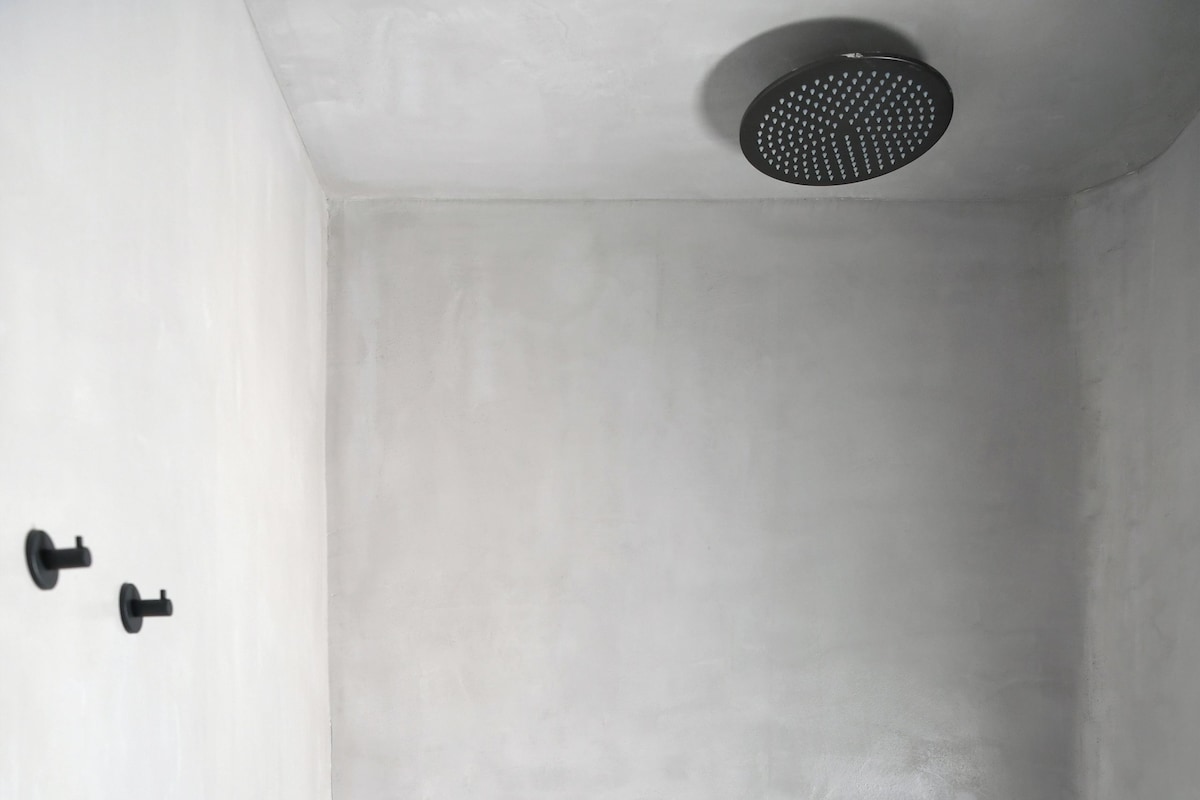 A bathroom with a shower, a towel rack, and a toilet.