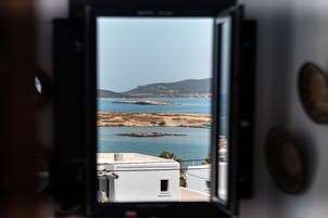 A camera with a view of a coastal landscape, including water, rocks, and distant hills.