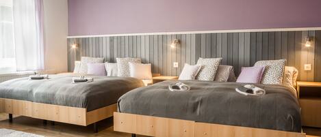 A double room with two beds, each with a headboard, bedside tables, and lamps.