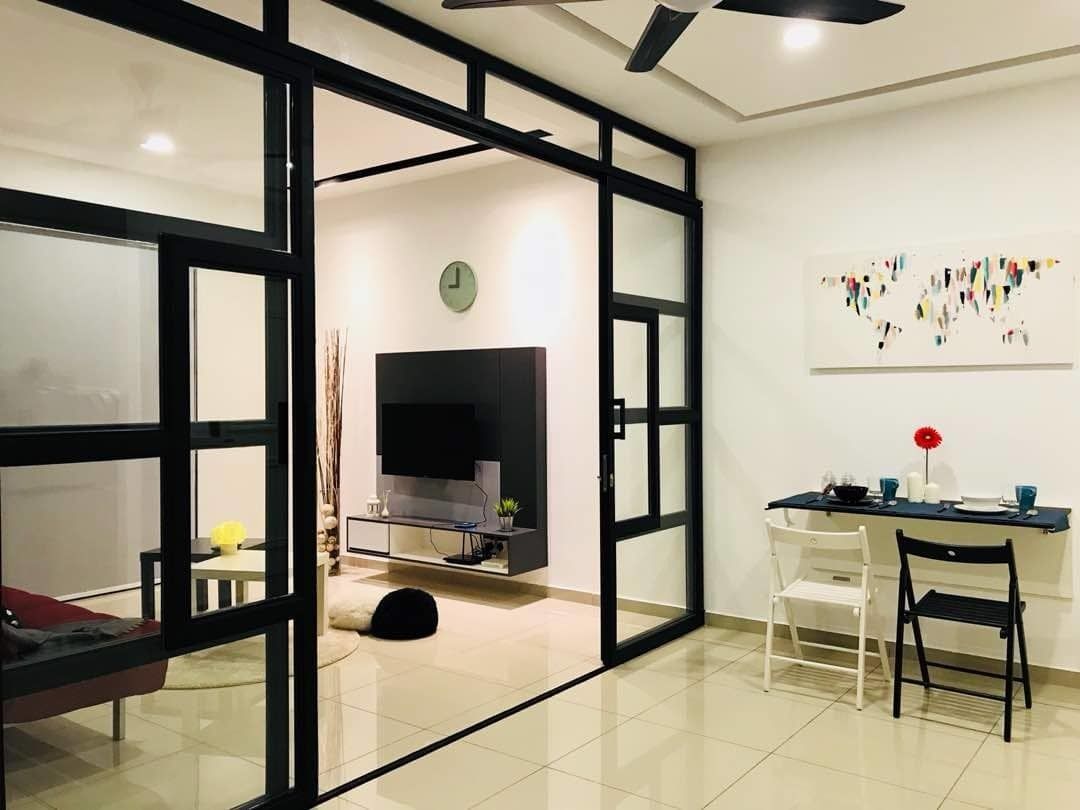 Una sala moderna con un sofá, una mesa de comedor con sillas, un televisor y un adorno en la pared.