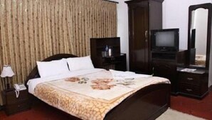 A hotel room with a bed, a television, a wardrobe, and a mirror. - Hotel Aradhya Palace (Kathmandu)