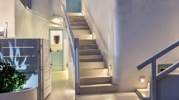 A staircase leading to a second floor with a light blue door at the top.