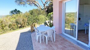 Un patio con tavolo e sedie, una recinzione in legno e vista sulla campagna.