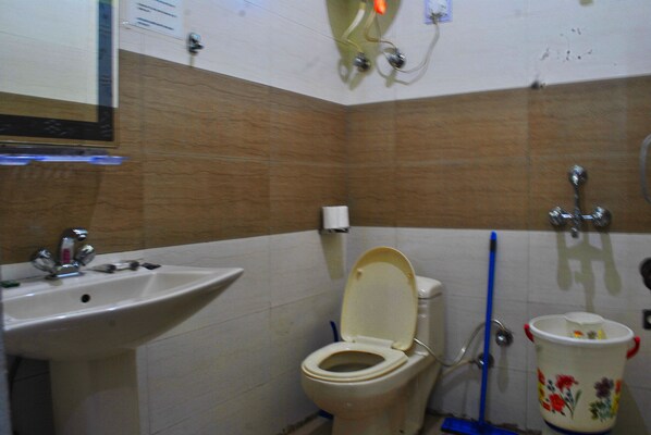 A bathroom with a sink, toilet, and mop.