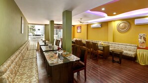 A restaurant with a long counter, booths, and a patterned wall. - Windsor Castle Inn (Bengaluru)