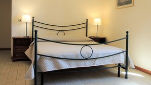 A bed with a metal frame, two bedside tables, and two lamps.