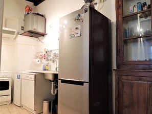A kitchen with a stainless steel refrigerator, a built-in oven, and a sink.