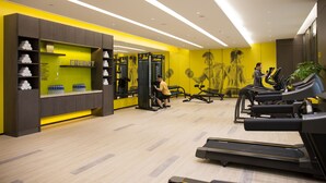 A modern gym with exercise equipment, a water station, and a yellow and grey color scheme. - The Mulian Hotel Suzhou Branch (Suzhou)