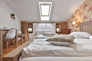 A bedroom with a skylight, a desk, a chair, a bed with white bedding, and a floral wallpaper. - Casa Muntelui Fundata (Moieciu de Jos)
