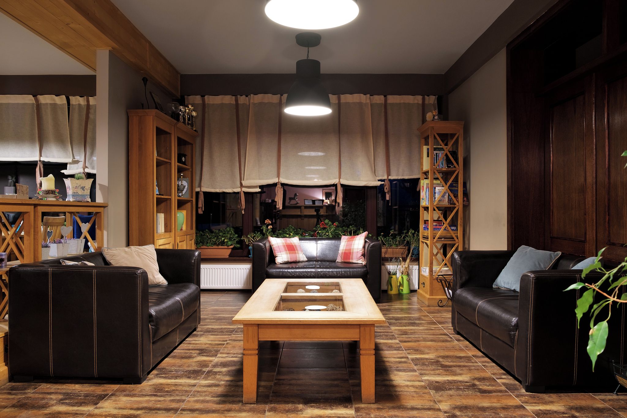 Una sala de estar acogedora con dos sofás de cuero, una mesa de centro de madera y una estantería.