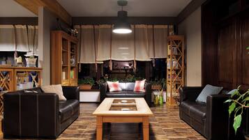 Una sala de estar acogedora con dos sofás de cuero, una mesa de centro de madera y una estantería.