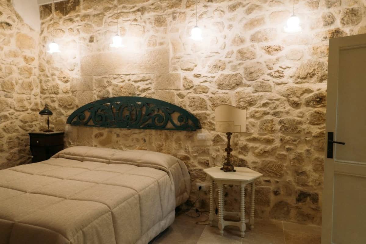 Ein Schlafzimmer mit Stewand, einem Bett, einem Nachttisch, einer Lampe und einem kleinen Tisch.