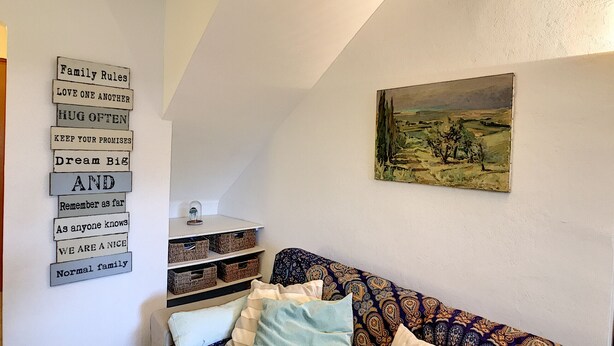A cozy living room with a patterned sofa, a wall-mounted shelf with baskets, and a framed landscape painting. - Maison LE PIGEONNIER 2 dans résidence privée (Le Plan-de-la-Tour)