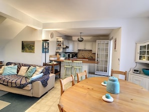 Relax in this inviting living space with a comfortable sofa, dining table for four, and a well-equipped kitchen.