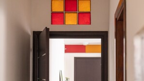 A doorway with a black frame, a small potted plant, and a wall-mounted light fixture. - Comfort House 14 (Roseto degli Abruzzi)