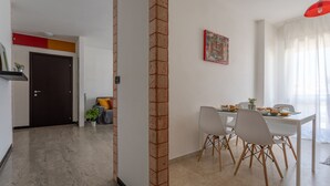 A modern dining area with a white table, four chairs, and a red pendant light. - Comfort House 14 (Roseto degli Abruzzi)