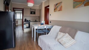 A compact living space with a kitchenette, dining area, and a sofa. - 2 bedroom apartment-Expo Residence Rho (RHO)