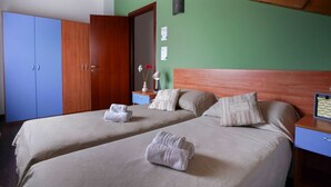 A hotel room with two beds, wooden headboards, a nightstand, and a wardrobe. - 2 bedroom apartment-Expo Residence Rho (RHO)