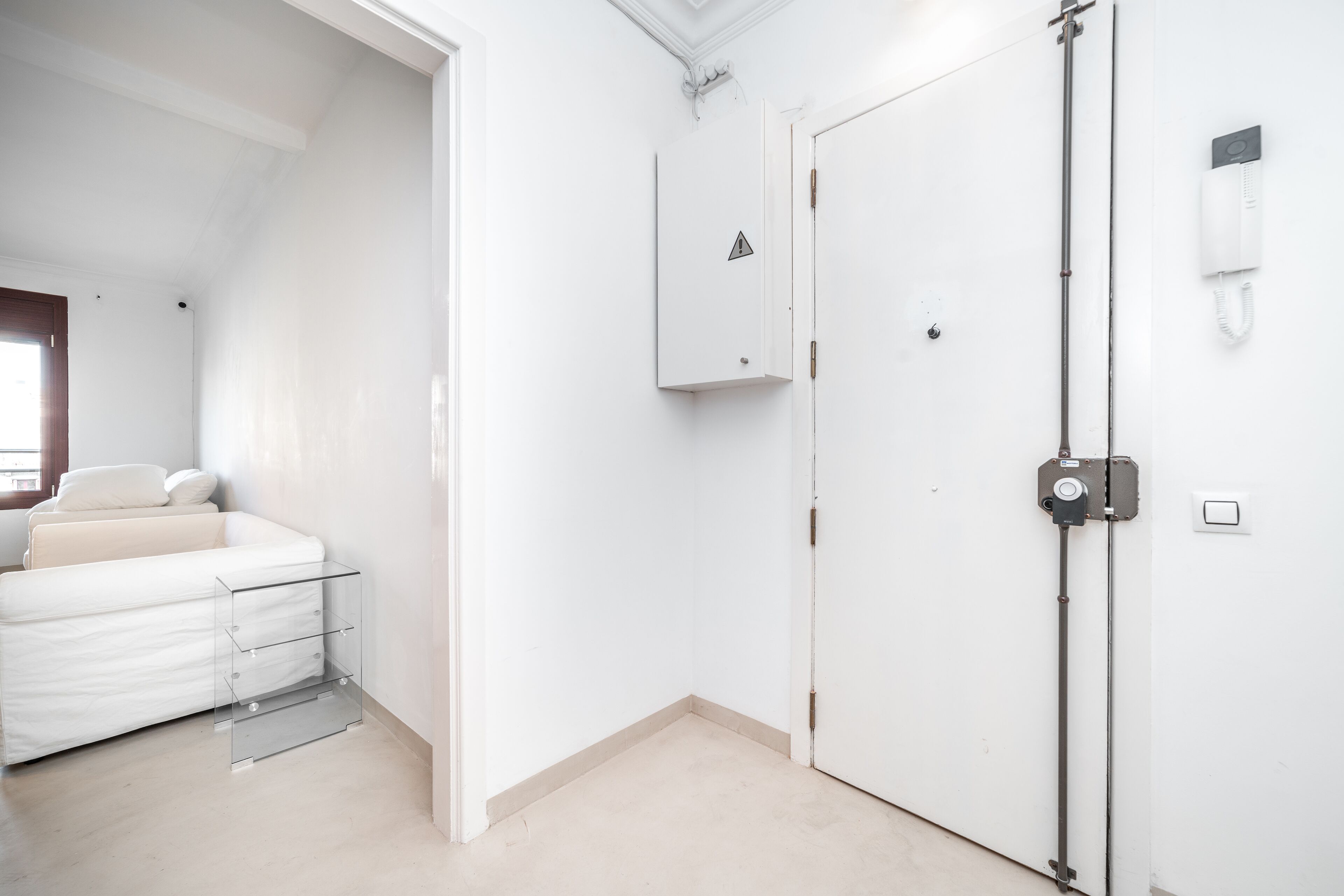 Une chambre d’hôtel comprenant un lit, une table de chevet, une armoire et un téléphone.