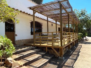 Un patio con bancos de madera y una estructura de pérgola.