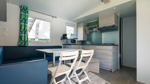 Una cocina compacta con zona de comedor, que incluye una mesa, sillas, microondas y estufa.