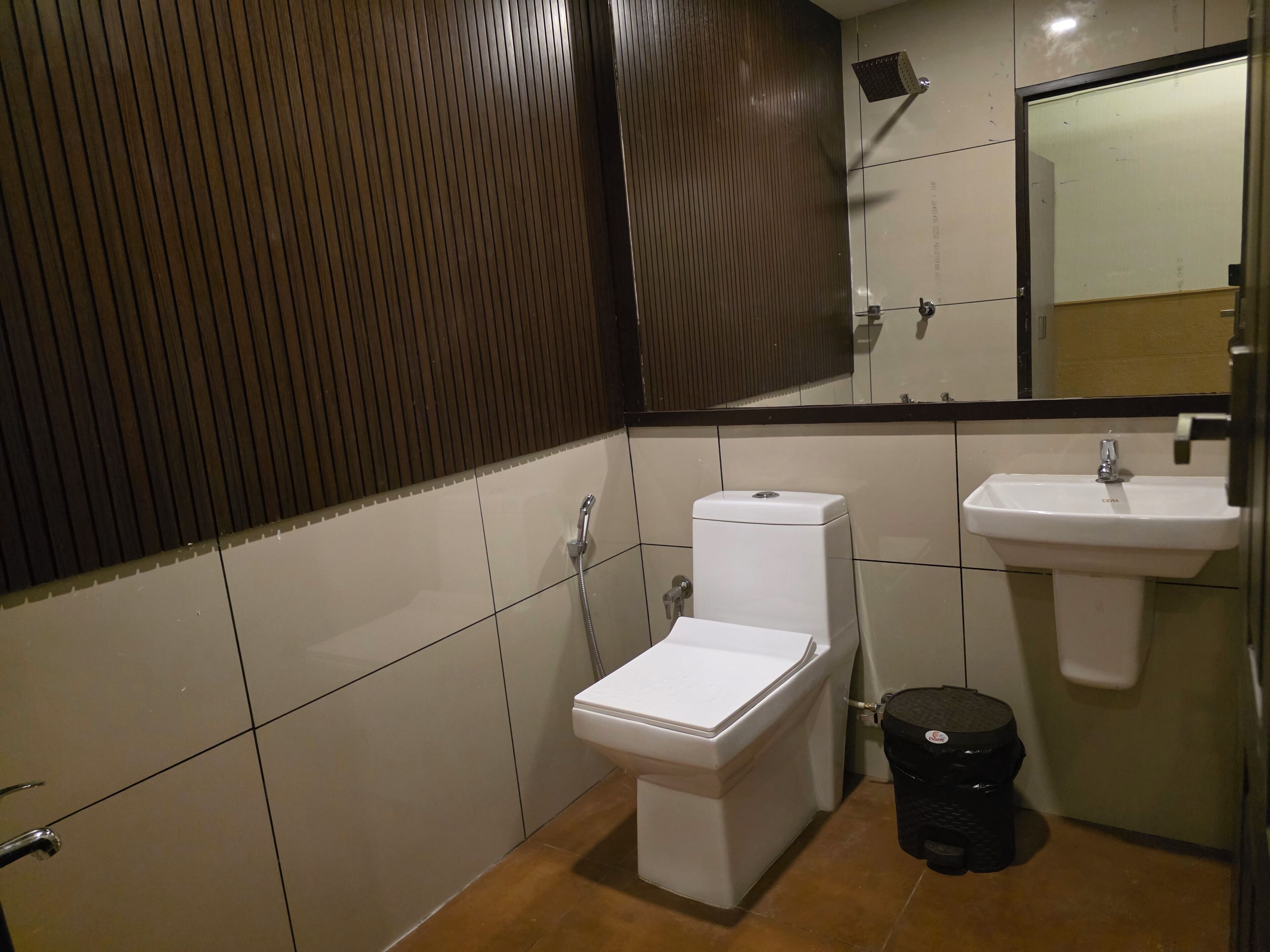 Un baño pequeño y moderno con inodoro, lavamanos y ducha.