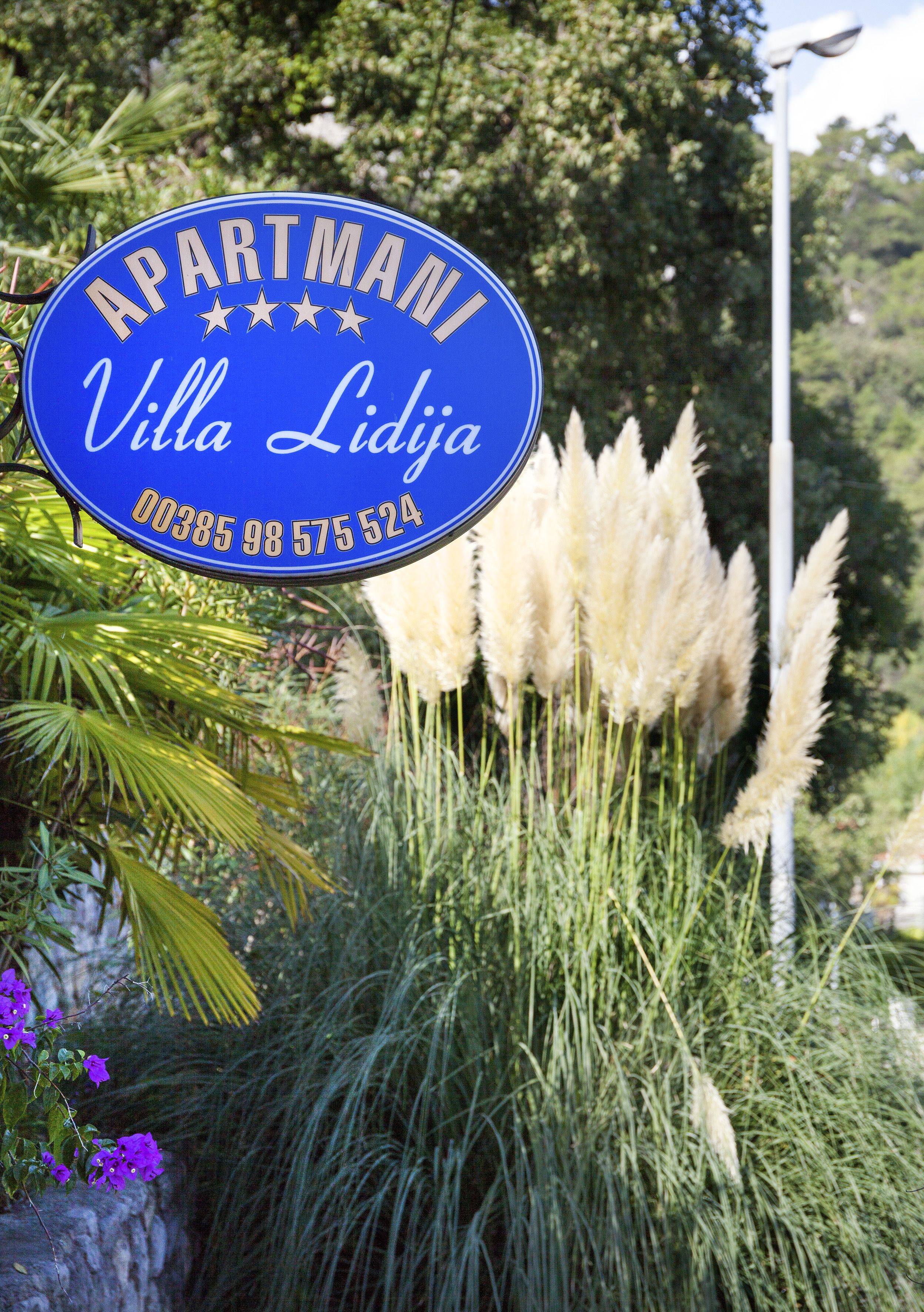 Ein Schild vor einem Apartmenthaus mit dem Namen "Villa Lidja" und einer Telefonnummer.