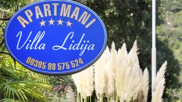 Ein Schild vor einem Apartmenthaus mit dem Namen "Villa Lidja" und einer Telefonnummer.