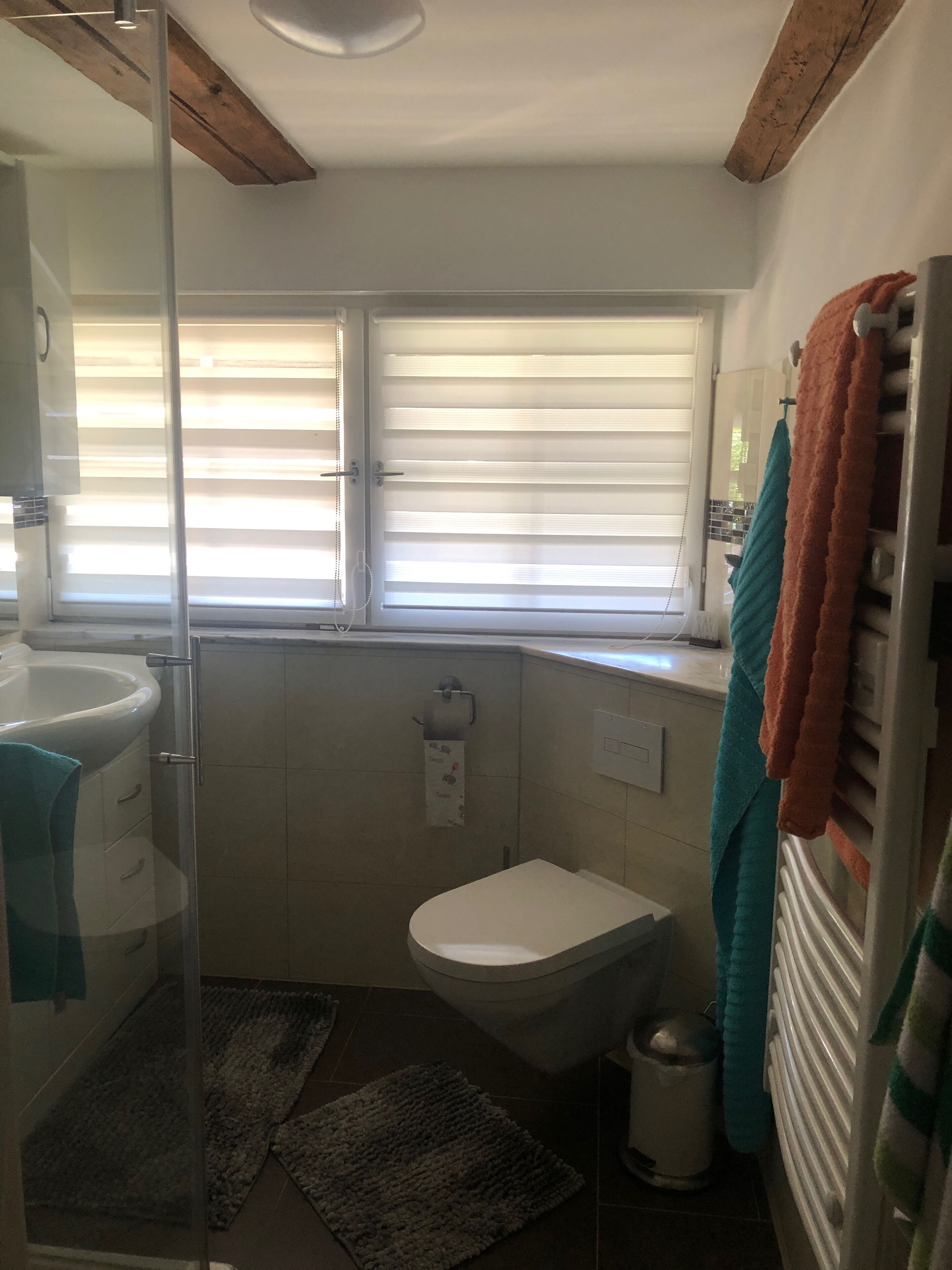 A bathroom with a toilet, sink, and shower area.