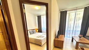 A hotel room with a bed, a desk, and a chair.