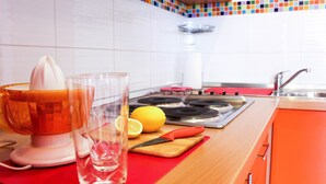 Una cocina con un exprimidor de frutas, un vaso de agua, un limón y una tabla de cortar sobre la encimera.